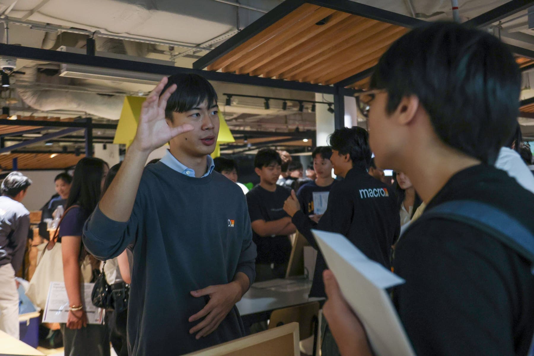 A MACRO teacher talking with students at a past event